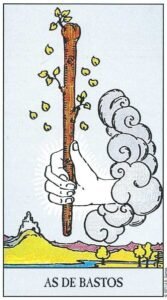 Carta del As de Bastos del Tarot Rider Waite: una mano divina surgiendo de una nube que sostiene un tronco florecido con hojas brotando sobre un paisaje lejano.