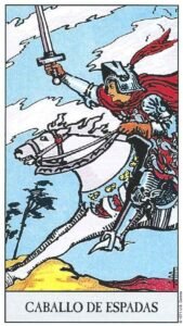 Carta del Caballo de Espadas del Tarot Rider Waite: un caballero sobre un caballo blanco al galope, blandiendo una espada hacia adelante bajo nubes agitadas.
