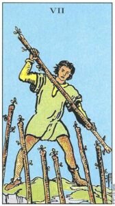 Carta del Siete de Bastos del Tarot Rider Waite: un hombre en una posición elevada defendiéndose con un bastón contra otros seis que lo atacan desde abajo.
