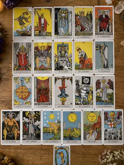Los 22 Arcanos Mayores del Tarot Rider-Waite dispuestos en una composición artística sobre tela clara.